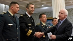 U.S. Senator John McCain, right, shakes hands with Montenegrin army officers in Podgorica, Montenegro, April 12, 2017. 