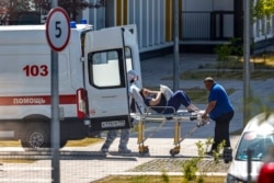 Medical workers carry a patient suspected of having coronavirus on a stretcher at a hospital in Kommunarka, outside Moscow, Russia, June 26, 2021.