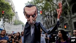 Protesters march holding a giant puppet representing President Mauricio Macri during a demonstration in Buenos Aires, Argentina, March 30, 2017. Unions and social groups are protesting the adjustment policies of Argentina's President. 