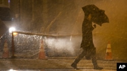 A pedestrian walks into the wind and snow in the financial district, in New York, November 7, 2012. 