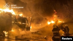 Firefighters extinguish fire in trucks at a site where warehouse facilities were hit during a Russian drone strike, amid Russia's attack on Ukraine, in the village of Murovane, outside of Lviv, Ukraine Sept. 6, 2024. (Press service of the State Emergency Service of Ukraine)