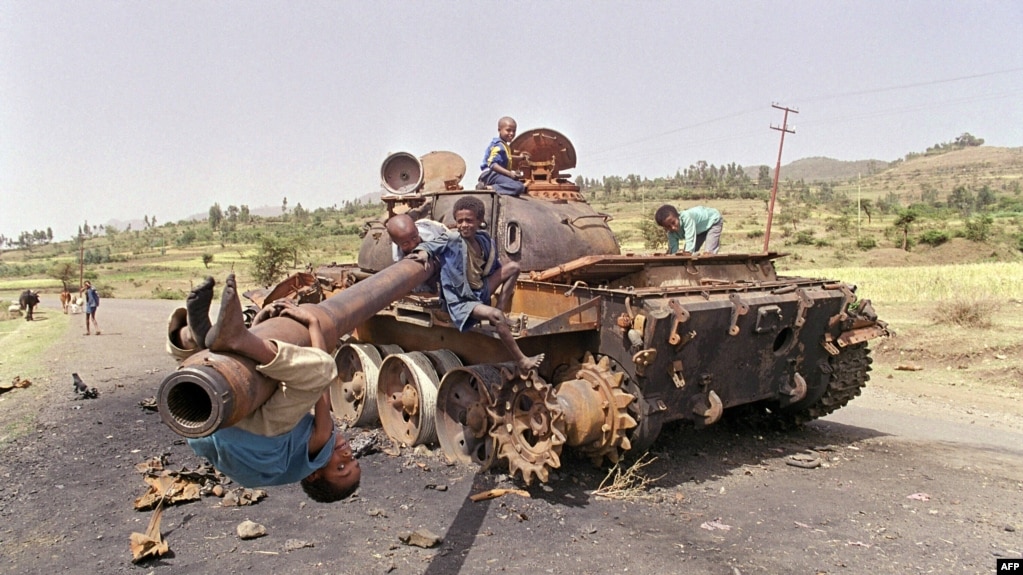 FILE - Eritrean children play on a destroyed Ethiopian army tank, June 7, 1991, near Amara, Eritrea.