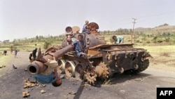 FILE - Eritrean children play on a destroyed Ethiopian army tank, June 7, 1991, near Amara, Eritrea.