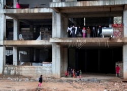 FILE - Yazidi families displaced by Islamic State group militants take shelter in a partially constructed building in Dohuk, northern Iraq, Dec. 10, 2014.