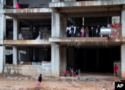 FILE - Yazidi families displaced by Islamic State group militants take shelter in a partially constructed building in Dohuk, northern Iraq, Dec. 10, 2014.