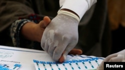 A medical worker helps a woman to draw blood for a HIV test at the free medical camp in Ratodero, Pakistan May 25, 2019. (REUTERS/Akhtar Soomro)