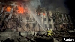 Petugas pemadam kebakaran bekerja di lokasi bangunan yang rusak akibat serangan rudal Rusia di Mykolaiv, Ukraina, dalam screengrab yang diambil dari video selebaran yang dirilis pada 27 April 2023. (Layanan Darurat Negara Ukraina/Handout via REUTERS)