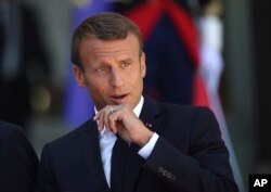 French President Emmanuel Macron pauses after greeting Britain's Prime Minister Boris Johnson at the Elysee Palace, Aug. 22, 2019 in Paris.