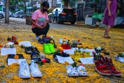 A woman looks at shoes displayed with flowers in Yangon's Myaynigone township, as part of the "Marching Shoes Strike" against the military coup in Myanmar, in this photo taken and received courtesy of an anonymous source on April 8, 2021.
