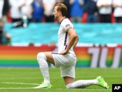 FILE - England's Harry Kane wears a rainbow armband as he takes the knee prior to the Euro 2020 soccer championship round of 16 match between England and Germany at Wembley Stadium in England. The captains of seven European nations will not wear anti-discrimination armbands in World Cup games after threats from FIFA to show yellow cards to the players. The seven soccer federations say "we can’t put our players in a position where they could face sporting sanctions.” (Justin Tallis, Pool Photo via AP)