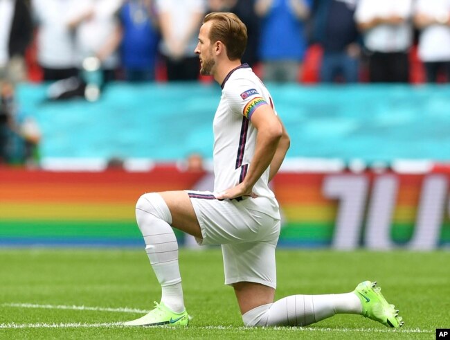 FILE - England's Harry Kane wears a rainbow armband as he takes the knee prior to the Euro 2020 soccer championship round of 16 match between England and Germany at Wembley Stadium in England. The captains of seven European nations will not wear anti-discrimination armbands in World Cup games after threats from FIFA to show yellow cards to the players. The seven soccer federations say "we can’t put our players in a position where they could face sporting sanctions.” (Justin Tallis, Pool Photo via AP)