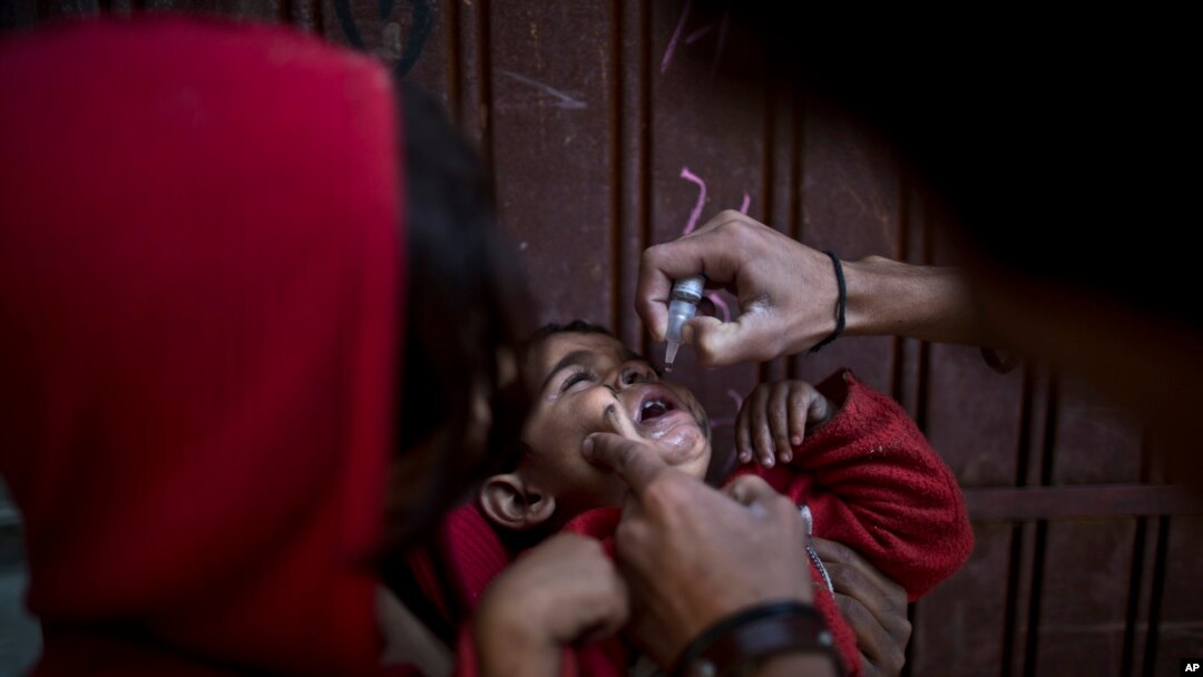 Seorang anak Pakistan mendapatkan vaksin polio dari petugas kesehatan di Islamabad, 26 November 2013. 