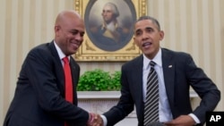 President Barack Obama and Haiti President Michel Martelly shake hands during a photo opportunity in the Oval Office of the White House in Washington, Feb. 6, 2014.