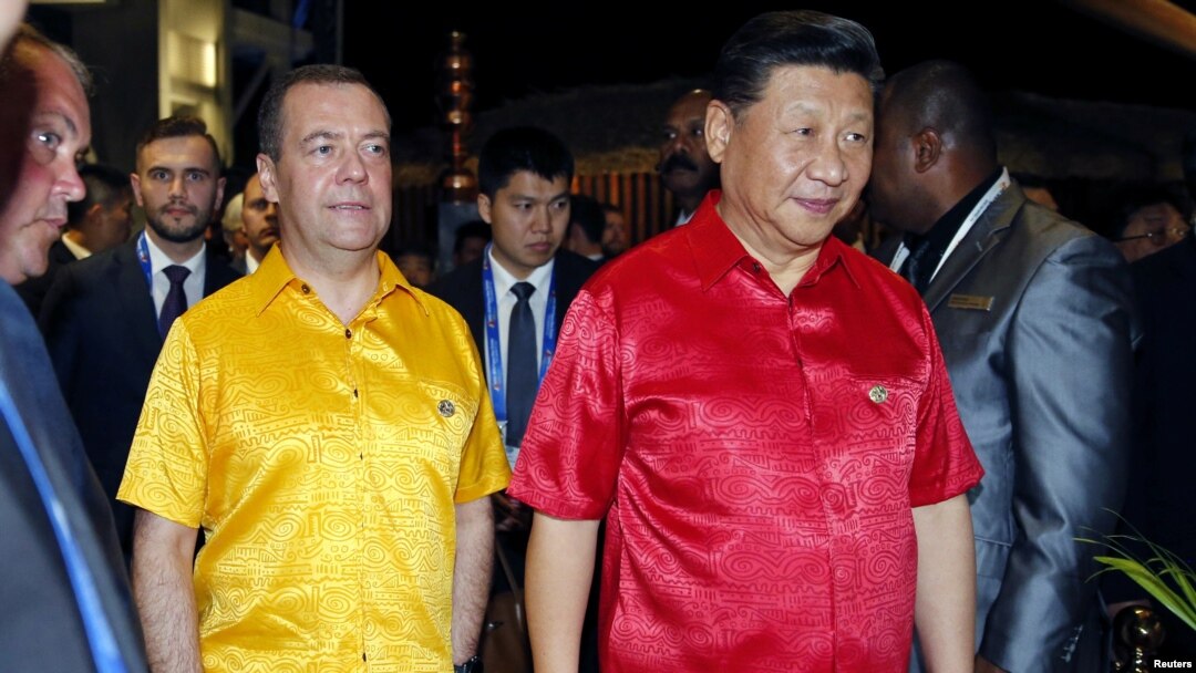 中国国家主席习近平身着巴布亚新几内亚红色民族服装前去参加APEC峰会领导人的集体合影。（2018年11月17日）