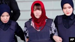 Vietnamese Doan Thi Huong, center, is escorted by police as she leaves Shah Alam High Court in Shah Alam, Malaysia, March 14, 2019. 