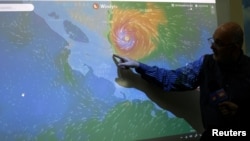 FILE - An official of the National Institute of Meteorology shows on a screen the advance of the Hurricane Otto in San Jose, Costa Rica, Nov. 24, 2016.