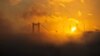 The sun rises behind the Grand Camlica Mosque as July 15 Martyrs' Bridge, known as the Bosphorus Bridge, and the Bosphorus are covered in fog in Istanbul, Turkey, Oct. 16, 2024.