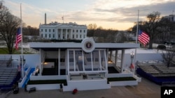 Workers continue with the finishing touches on the presidential reviewing stand on Pennsylvania Avenue outside the White House, Jan. 16, 2025, in Washington, ahead of President-elect Donald Trump's inauguration.