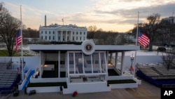 Workers continue with the finishing touches on the presidential reviewing stand on Pennsylvania Avenue outside the White House, Jan. 16, 2025, in Washington, ahead of President-elect Donald Trump's inauguration.