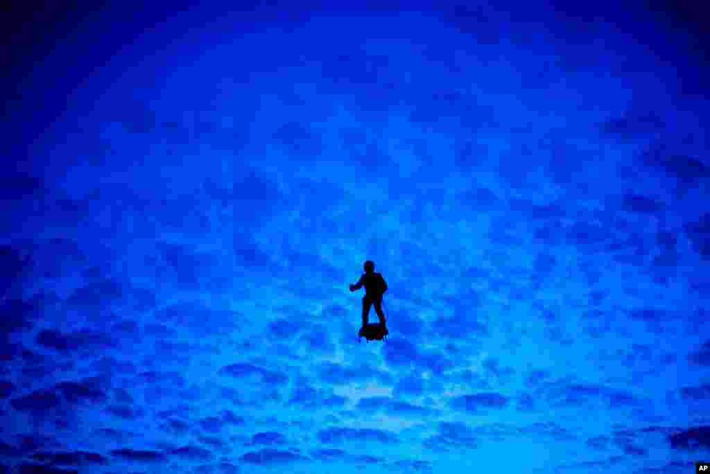 A French soldier on a hoverboard rehearses for landing on the Champs Elysees avenue for the Bastille Day parade, in Paris. Bastille Day parade will take place Sunday.
