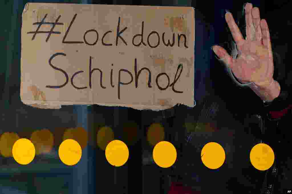 The hand of an activist is glued to a revolving door of one of the entrances to Schiphol Airport, near Amsterdam, Netherlands. 