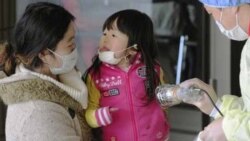 Mother and daughter receive radiation scanning in Fukushima, northern Japan, one week after a massive earthquake and tsunami.