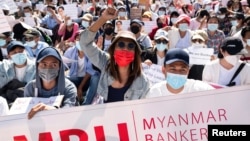 Demonstrators rally outside the Central Bank of Myanmar during a protest against the military coup and to demand the release of elected leader Aung San Suu Kyi, in Yangon, Myanmar, Feb. 11, 2021.