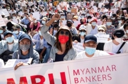 FILE - Demonstrators rally outside the Central Bank of Myanmar during a protest against the military coup and to demand the release of elected leader Aung San Suu Kyi, in Yangon, Myanmar, Feb. 11, 2021.