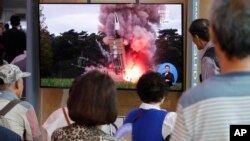 People watch a TV showing a file image of a North Korea's missile launch during a news program at the Seoul Railway Station in Seoul, South Korea, Tuesday, September 10, 2019. 