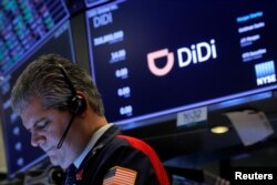 FILE - A trader works during the initial public offering for shares of Chinese ride-hailing company Didi Global Inc. on the New York Stock Exchange floor in New York, June 30, 2021.