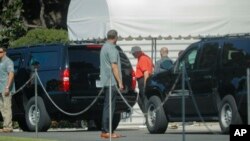 El presidente Donald Trump (centro) con una camisa polo color naranja, por abordar un vehículo frente a la Casa Blanca el lunes, 3 de septiembre de 2018. Momentos después Trump retorna a la mansión presidencial.