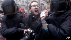 FILE - Riot policemen detain a journalist during a protest rally in St. Petersburg, Russia, March 26, 2017.