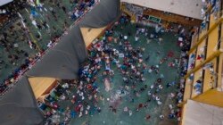 Inmates gather around the corpses of other inmates during a prison riot in Miguel Castro Castro prison, in Lima, Peru, Monday, April 27, 2020.