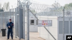 FILE - A Hungarian police officer patrols an enlarged transit zone that was set up for migrants at the Hungary's southern border with Serbia near Tompa, 169 kms southeast of Budapest, Hungary, April 6, 2017. 
