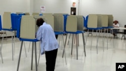 FILE - A voter marks her ballot at the Bowen Center in Pontiac, Michigan, Aug. 7, 2012. 