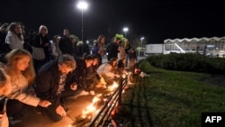 Građani Novog Sada pale sveće i polažu cveće u blizini zgrade železničke stanice gde se u petak obrušila nadstrešnica i usmrtile 14 osoba (Foto: AFP/ Nenad Mihajlović)