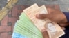 Un ciudadano sostiene un fajo de bolívares, la moneda local venezolana, en Caracas, Venezuela. 