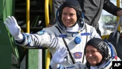 Astronot AS Jack Fischer, atas, dan kosmonot Rusia, Fyodor Yurchikhin, anggota kru misi ke Stasiun Antariksa Internasional, melambaikan tangan sebelum peluncuran dari kosmodrom Baikonur yang disewa pemerintah Rusia, di Kazakhstan, 20 April 2017. 