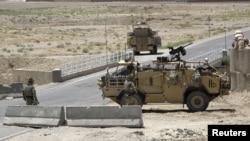 British troops keep watch at a checkpoint, where an Afghan policeman shot and killed three British soldiers, in Helmand province July 2, 2012.