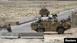 British troops keep watch at a checkpoint, where a man shot and killed three British soldiers, Helmand province, Afghanistan, July 2, 2012.