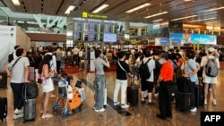 Los pasajeros formaron largas colas en el aeropuerto de Singapur debido a una importante interrupción del servicio informático en Singapur el 19 de julio de 2024. (Foto de Roslan RAHMAN / AFP)