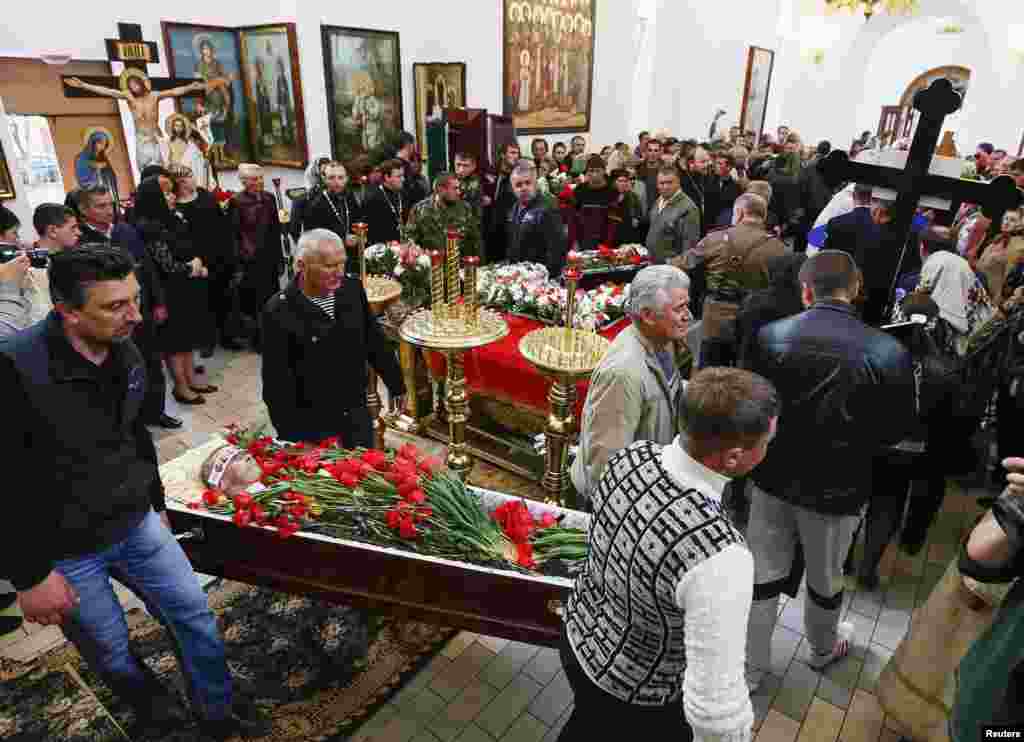 People carry coffins containing the bodies of men killed in a gunfight on April 20, during a funeral ceremony in Slovyansk, April 22, 2014.