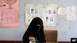 A woman casts her vote during the presidential elections at a polling station in Al Hasaba neighborhood in Sana'a February 21, 2012.