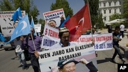 Uighurs living in Turkey hold a poster of Chinese Prime Minister Wen Jiabo with a banner that reads " the premier of the country of blood" as they march to the Chinese embassy in Ankara, Turkey, July 5, 2011