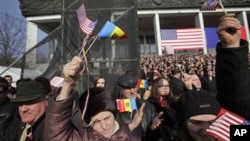 Moldovans wave American flags as US Vice President Joseph Biden speaks to several thousand people on a central square in Chisinau, Moldova, March 11, 2011