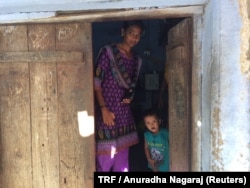 Poomalai Poomari and her niece at the door of their one-room home in Ayanapuram village in Tamil Nadu, India. July 27, 2017.