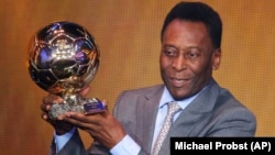 La légende du football brésilien Pelé exhibe le prix d'honneur qu'il a reçu à la FIFA Ballon d'Or 2013 Gala à Zurich , Suisse , le lundi 13 janvier, 2014. (AP Photo / Michael Probst )