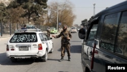 A Taliban fighter stands as he guards a checkpoint in Kabul, Afghanistan Nov. 27, 2021. 