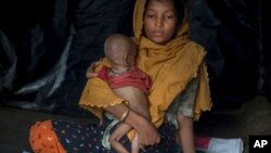 Seorang perempuan Muslim Rohingya menggendong bayinya berusia 10-bulan di kamp pengungsi Thaingkhali, Bangladesh, Sabtu (21/10) lalu. 