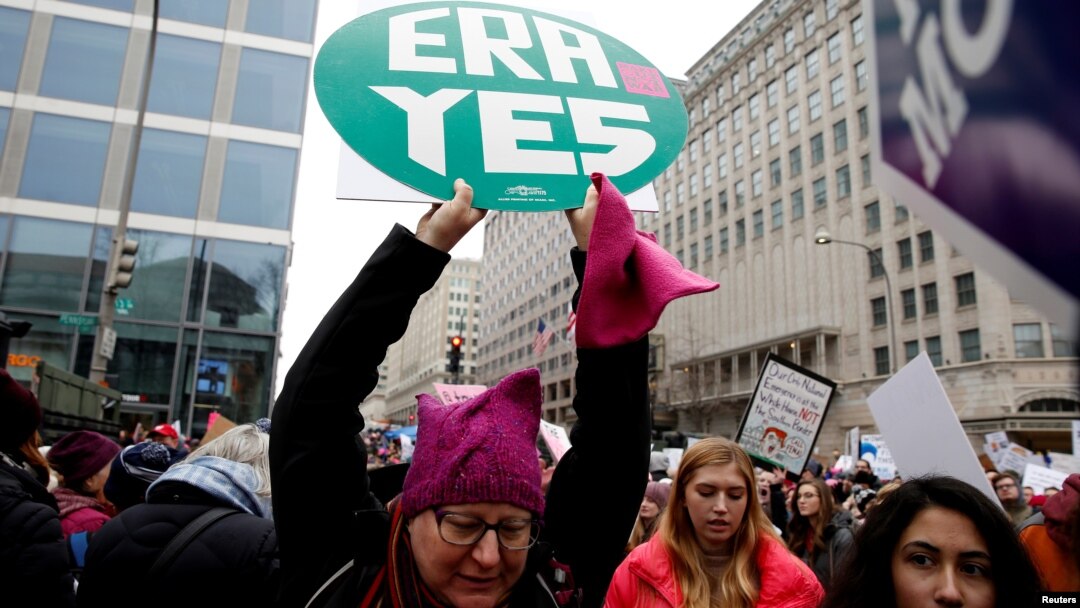 FILE - A demonstrator holds a sign calling for an equal rights amendment (ERA) during in the Third Annual Women's March at Freedom Plaza in Washington, Jan. 19, 2019. 